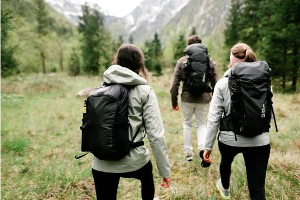 Aufnahme von drei Wanderern Wanderrucksäcken im sportlichen Look von hinten