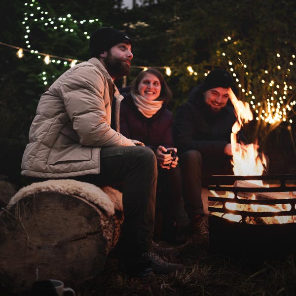 Drei Personen sitzen auf einem Schlitten im Schnee